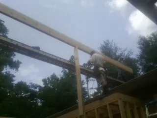 Carpenter setting a ridge beam over a new addition frame — Ice Dam Removal by Roofing Brothers in Locust Gap