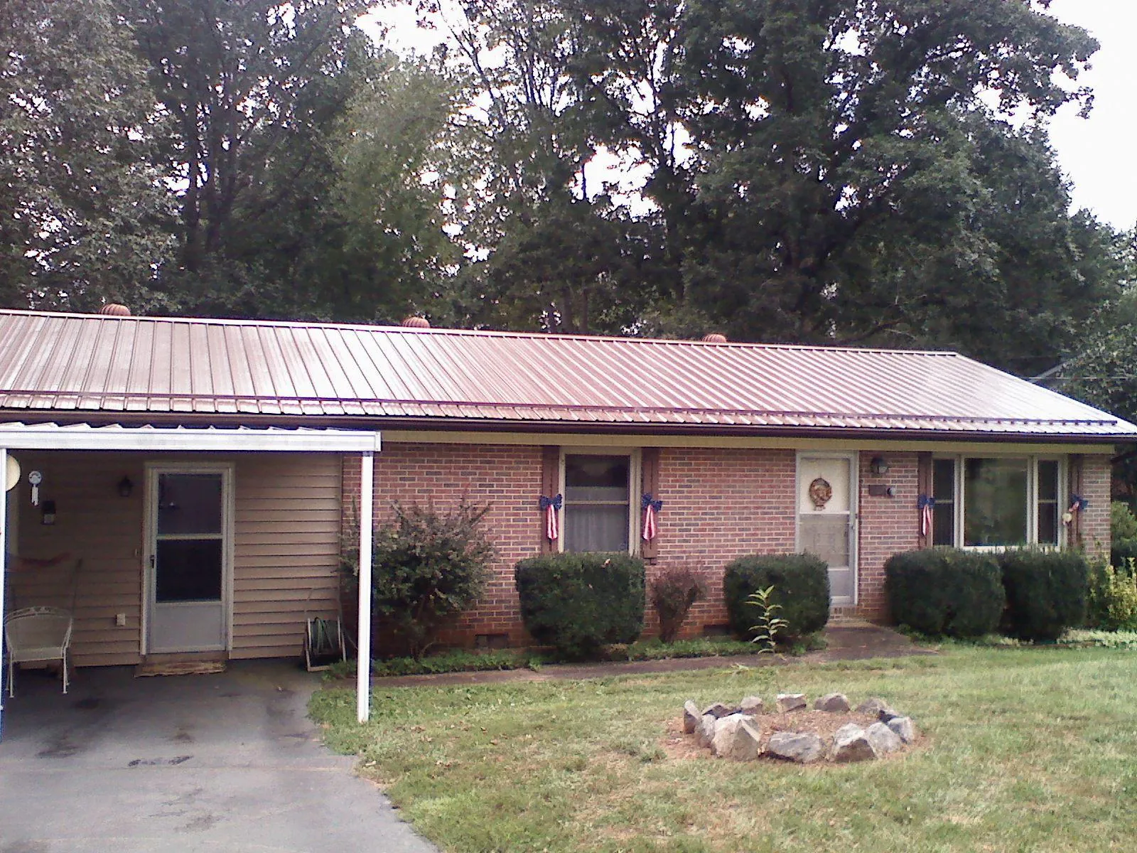 Bronze metal roof and carport on a brick ranch home — Roof Repair work by our crew in Locust Gap